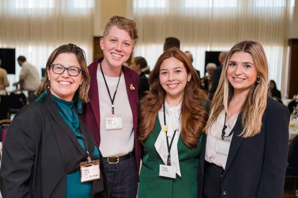 A group of four individuals smiling for photo.